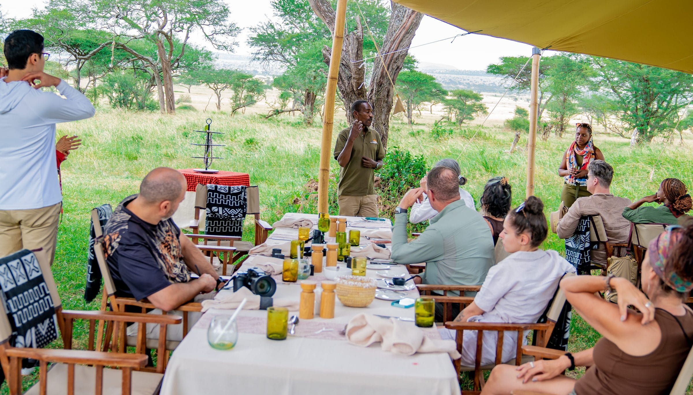 Amanda Kessy and the Still Waters team hosting a briefing at a bush table in the Serengeti