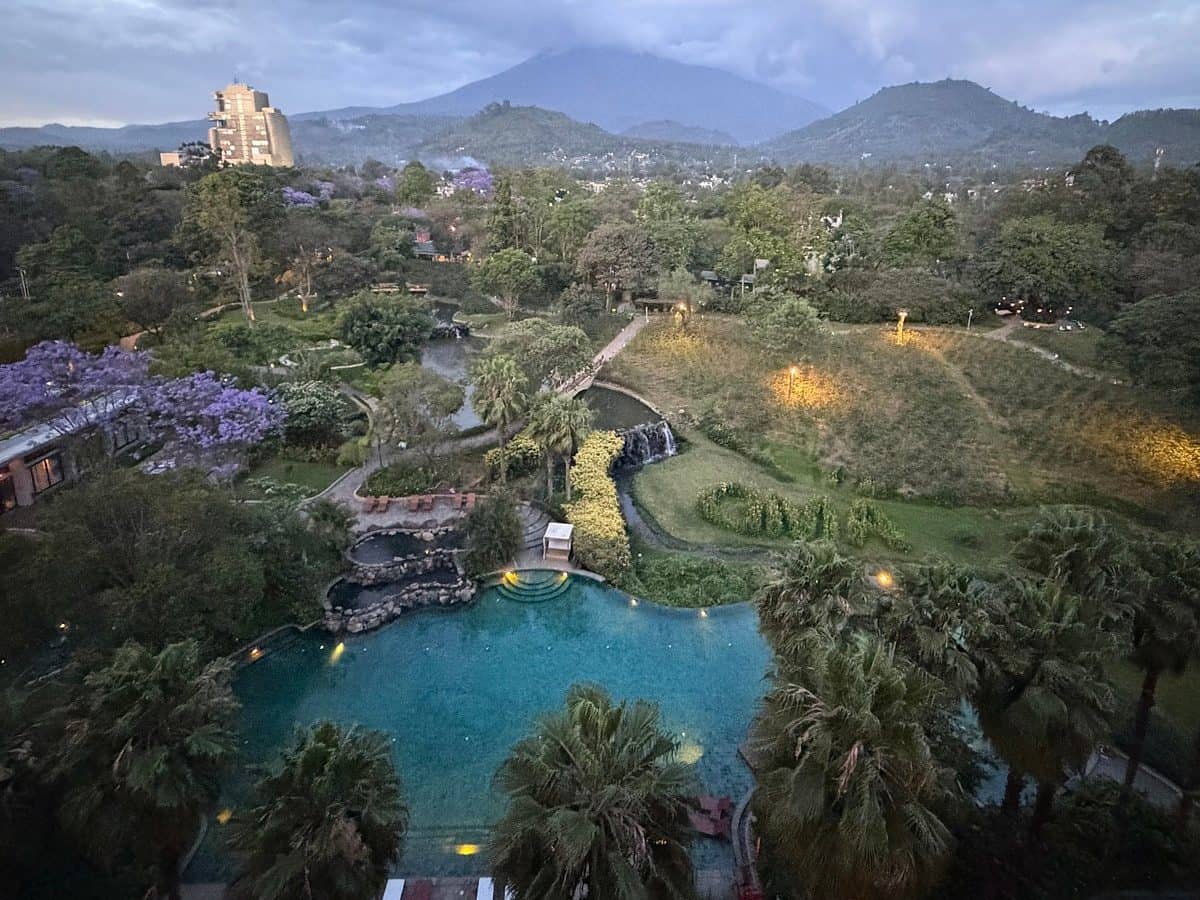 The gardens and pool of Gran Meliá Arusha at dusk, with Mount Meru beyond