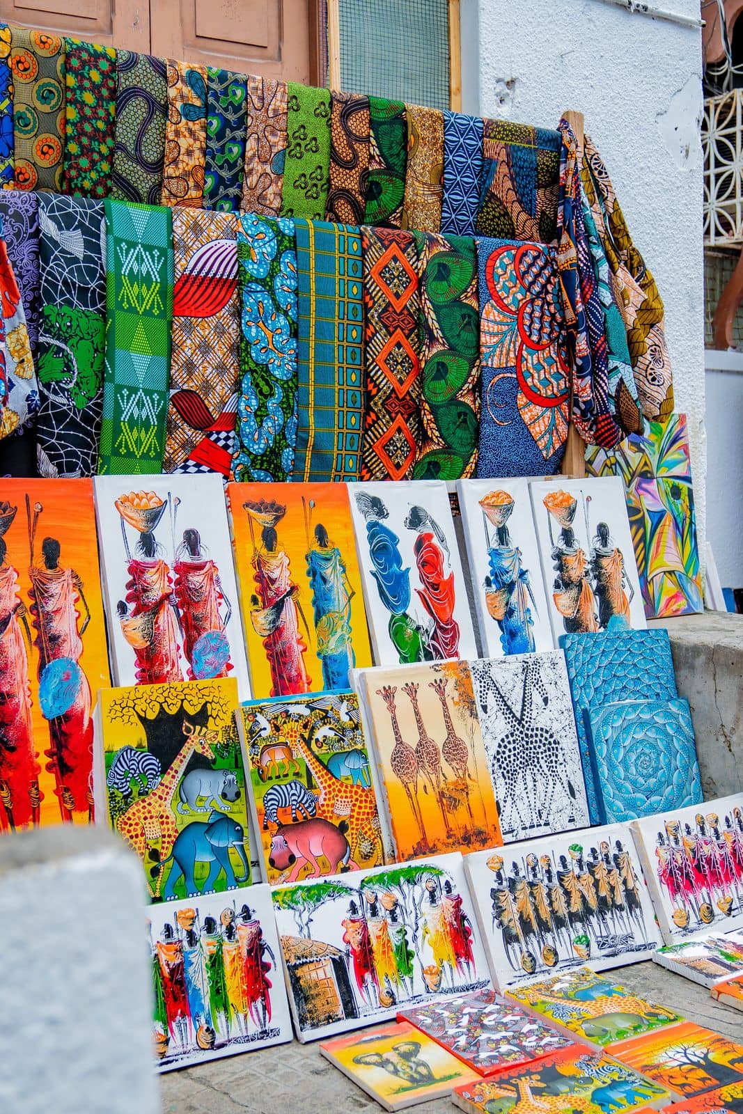 Colourful kanga fabrics and Tingatinga paintings for sale in Stone Town